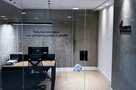 Entrada do escritório, com portas de vidro e a identificação Barreto Advogados Associados na parede.