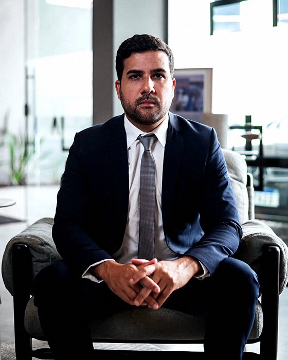 Renan Alonso Barreto, advogado, sentado em uma poltrona no escritório.
